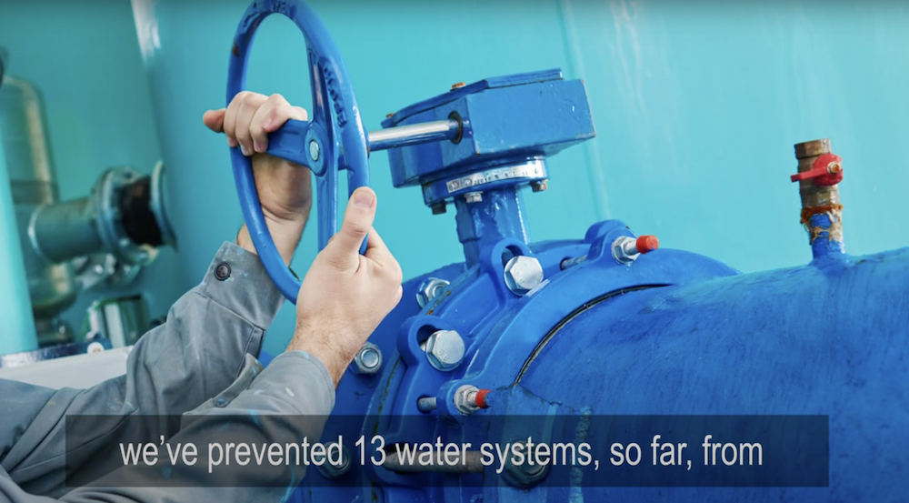 Preventing Arsenic Exceedances through Predictive Analytics with a hand turning off a large valve. Also has play button to watch/listen to a video. 